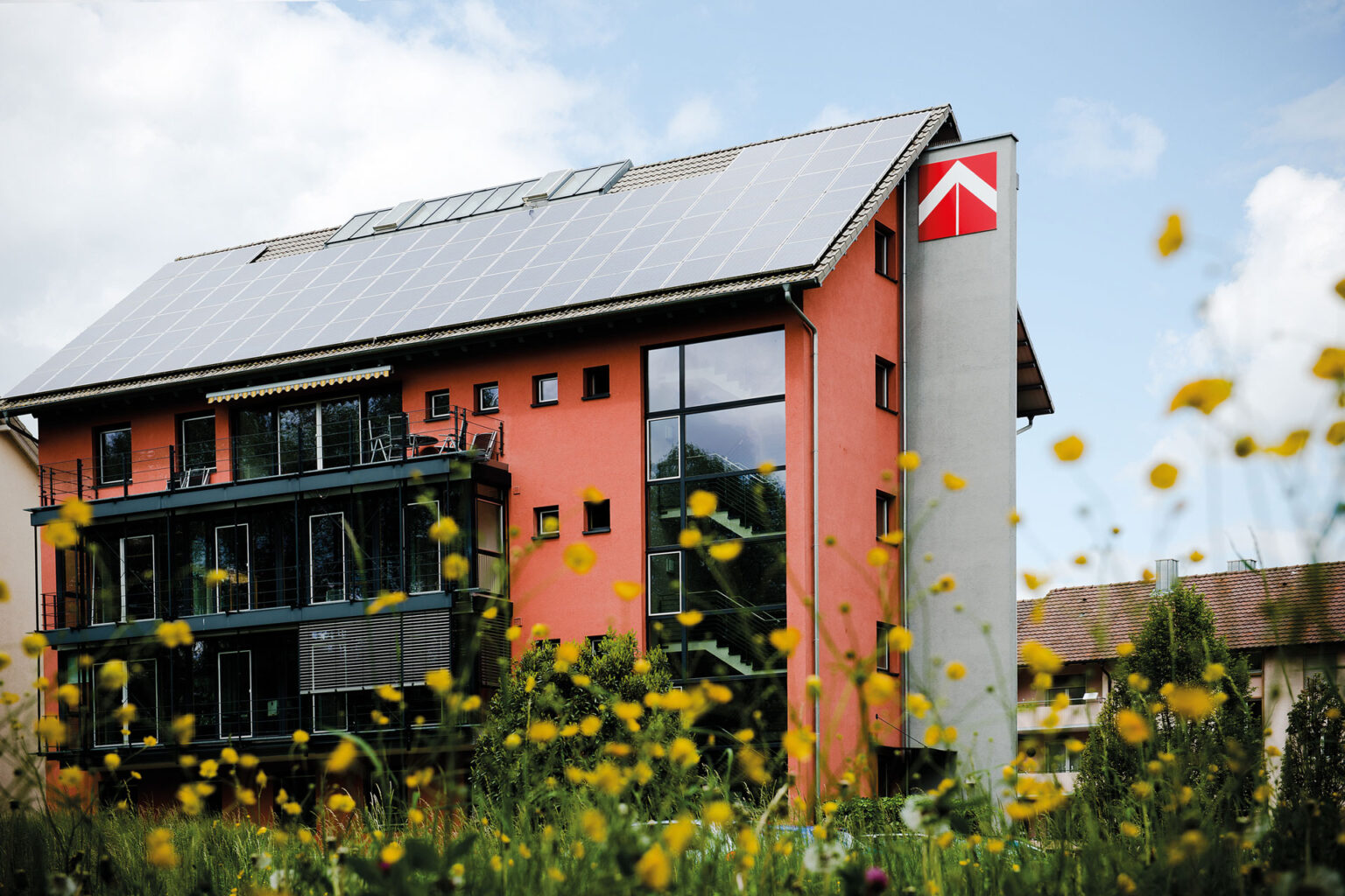 Bürogebäude der Baugenossenschaft Familienheim Bodensee mit blühenden Blumen davor